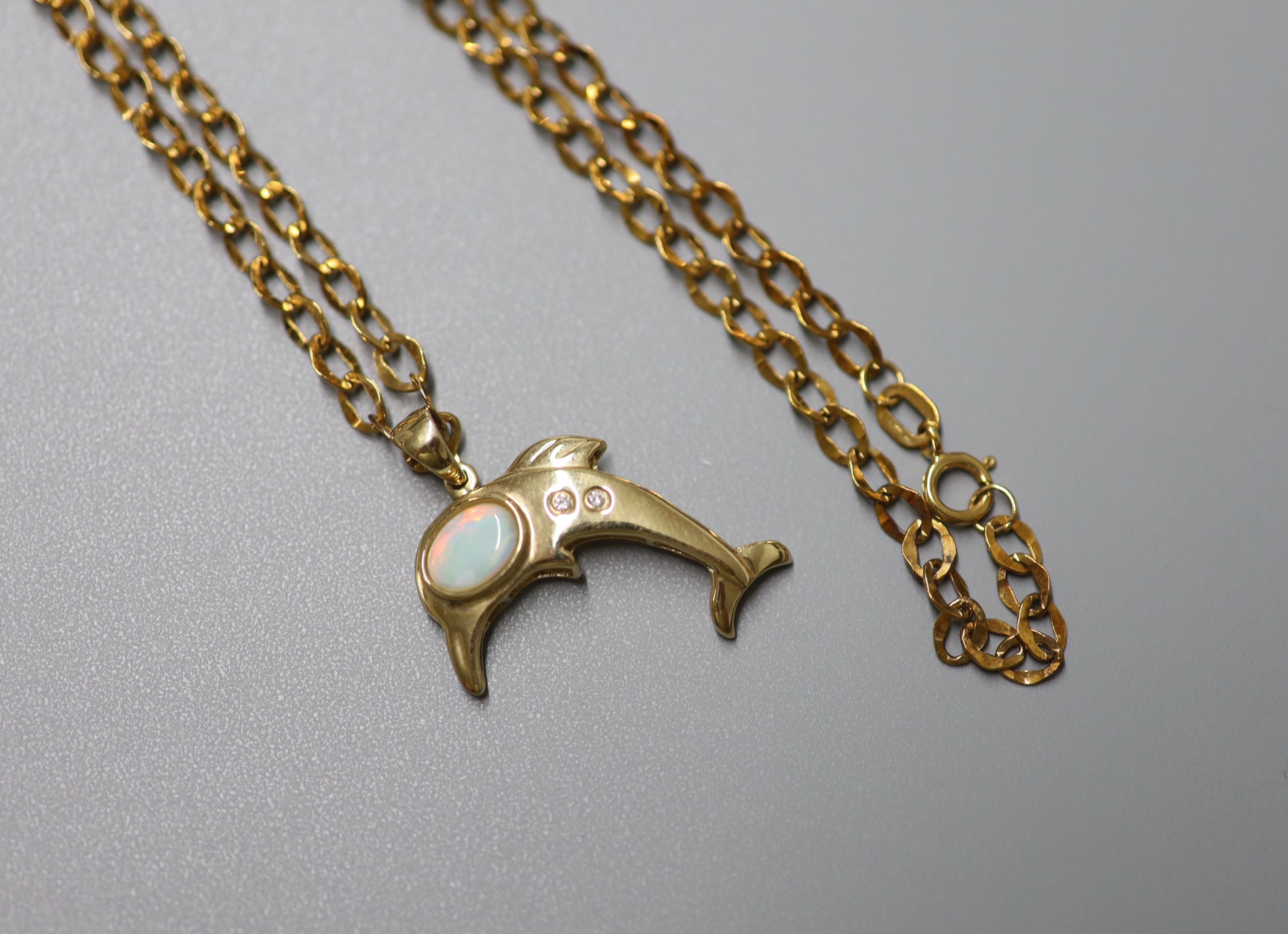 A modern 9ct gold, white opal and two stone diamond chip set dolphin pendant, 24mm, on a 9ct gold chain, 44cm, gross weight 2.9 grams.